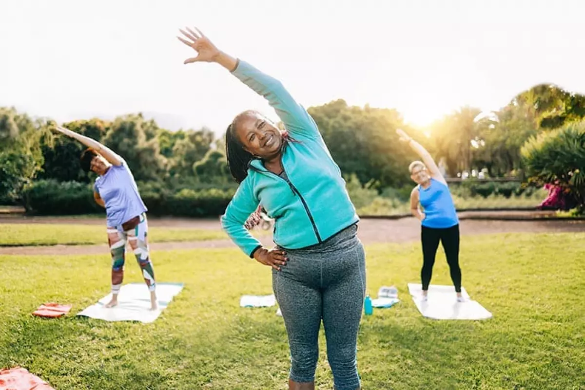 Women during a yoga workout at a park in their 55+ community.