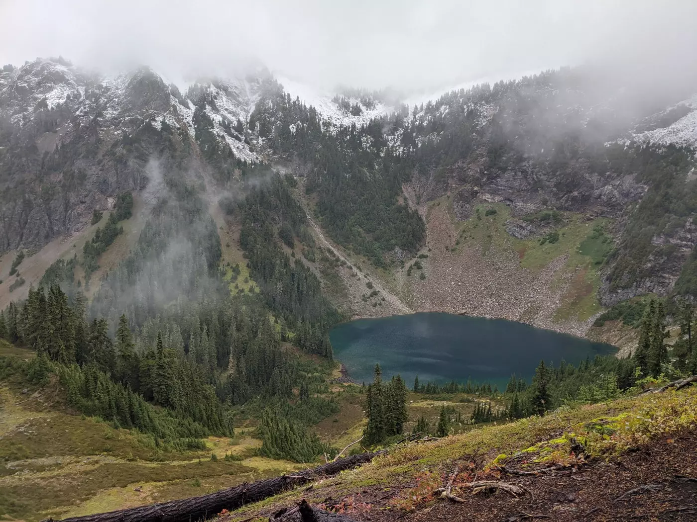 A small blue lake surrounded by steep gray mountains.