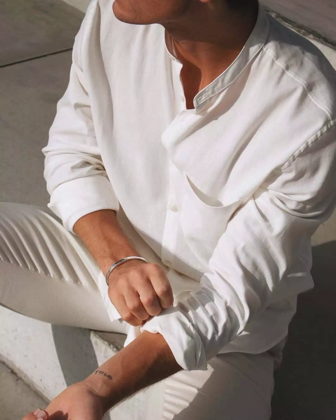 man wearing an off-white collarless shirt