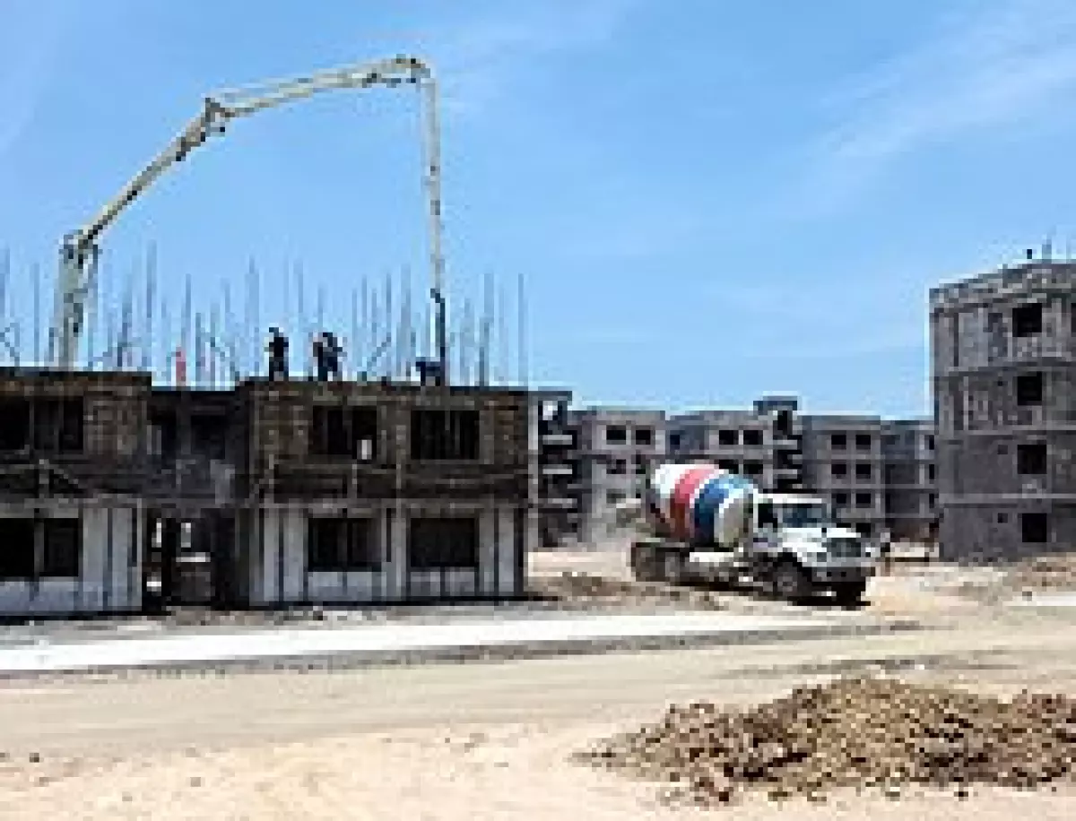 Cemex ready-mix truck departing jobsite after dispensing concrete for a multi-storey residential project. The location is Villahermosa, Mexico.